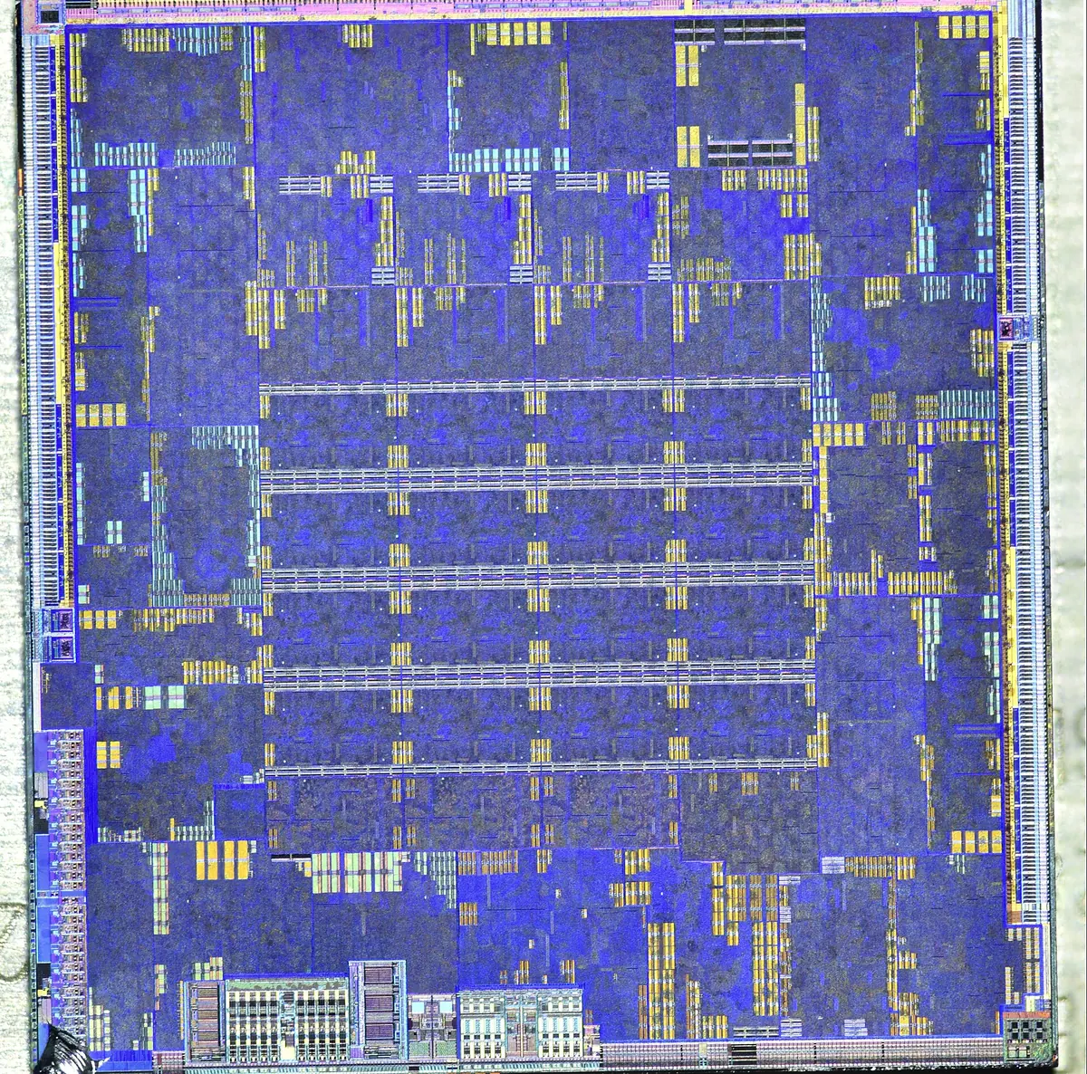 A microscope photograph of a chip die, showing coloured blocks of circuitry