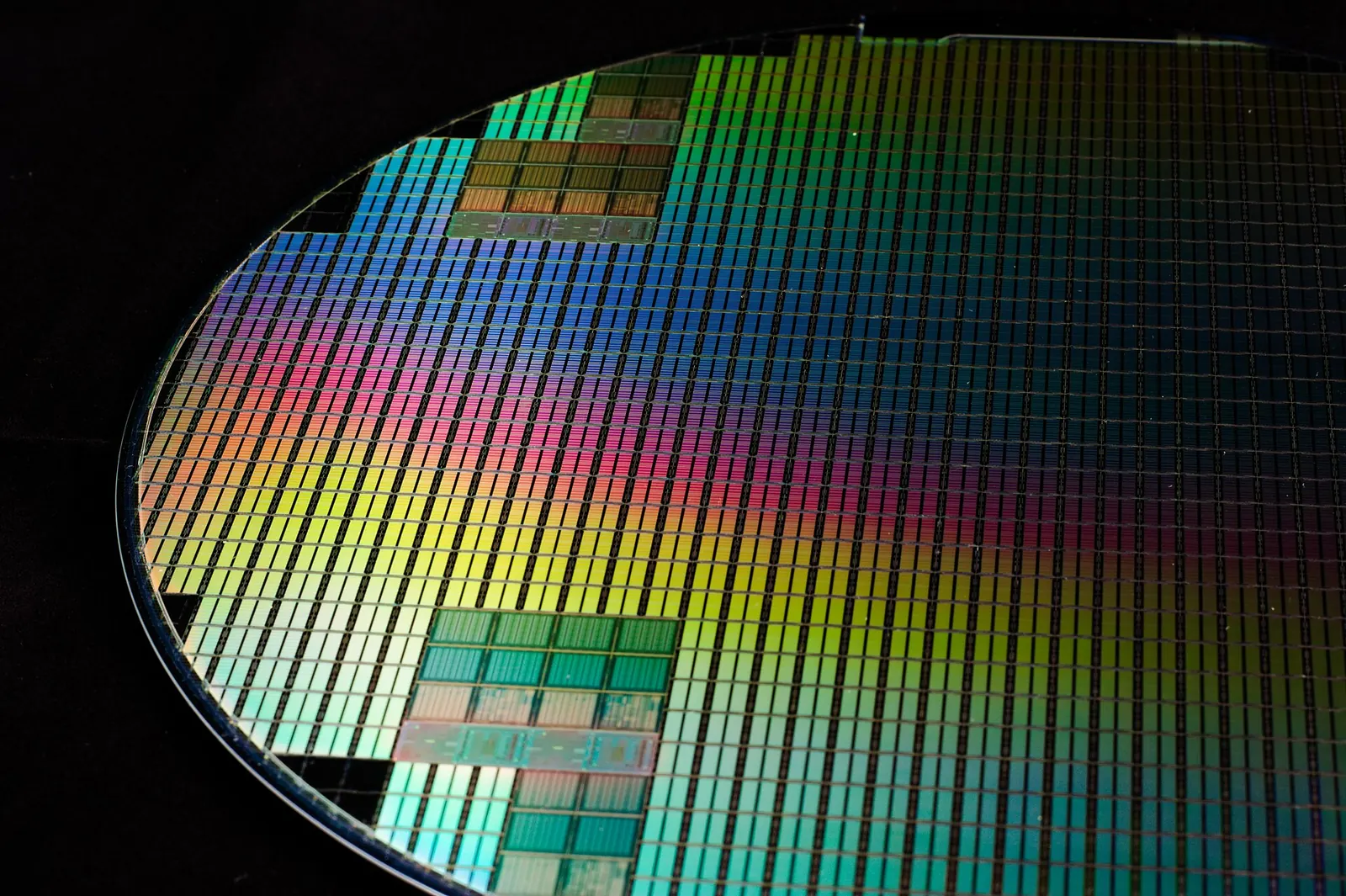 A silicon wafer covered in a grid of rainbow-coloured chips