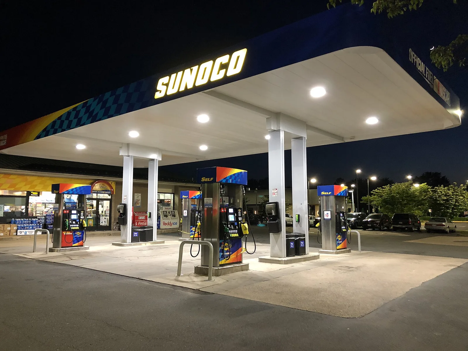 Petrol pumps at a filling station at night, marked out of service