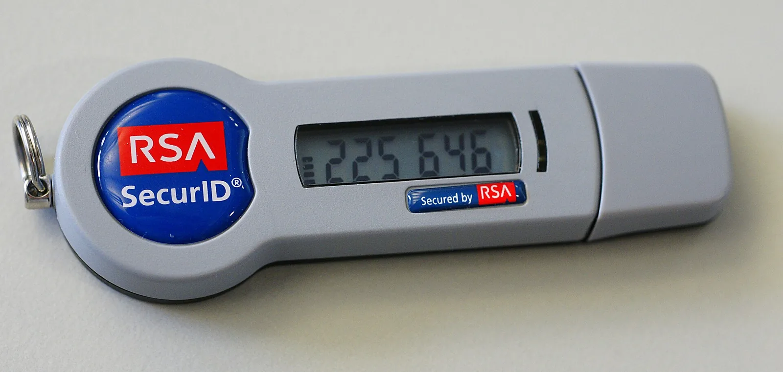 An RSA SecurID token showing a six-digit code on its display, with a USB connector