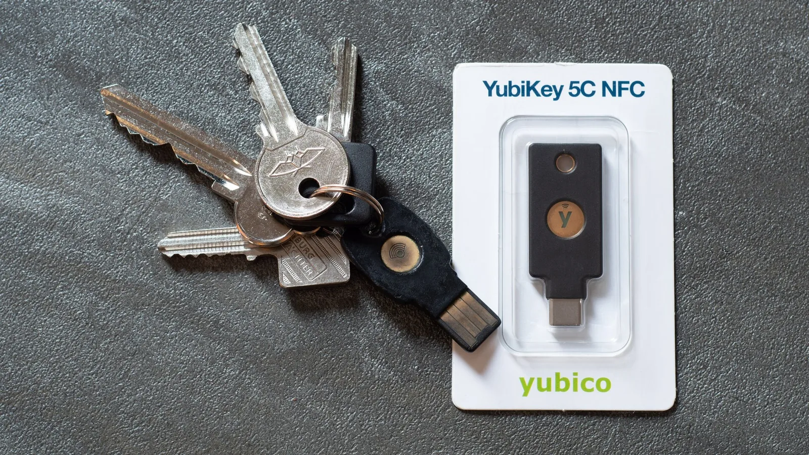 A YubiKey hardware security key on a keyring next to a new one in its packaging